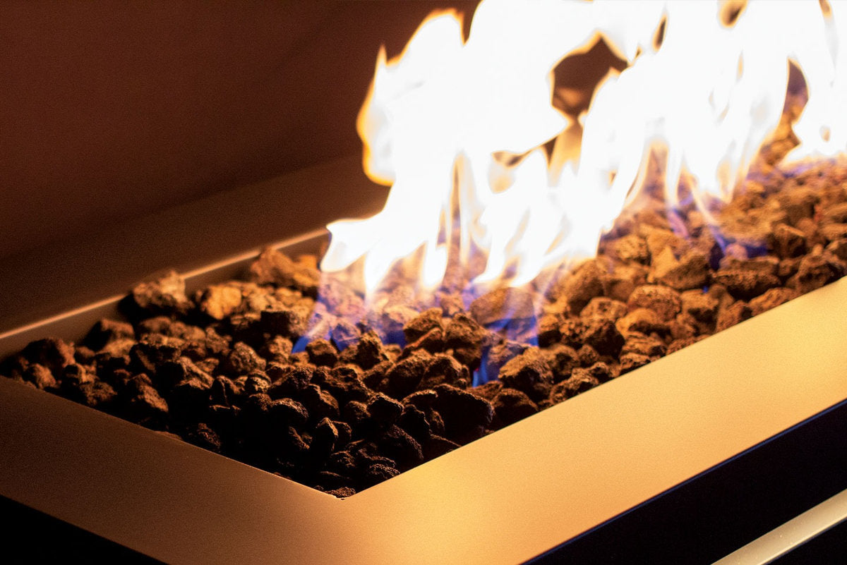 Close-up of Halo 60 gas fire pit flames burning over natural lava rocks.