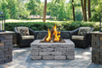 Halo 44 gas fire pit with rustic stone design and outdoor wicker seating area.