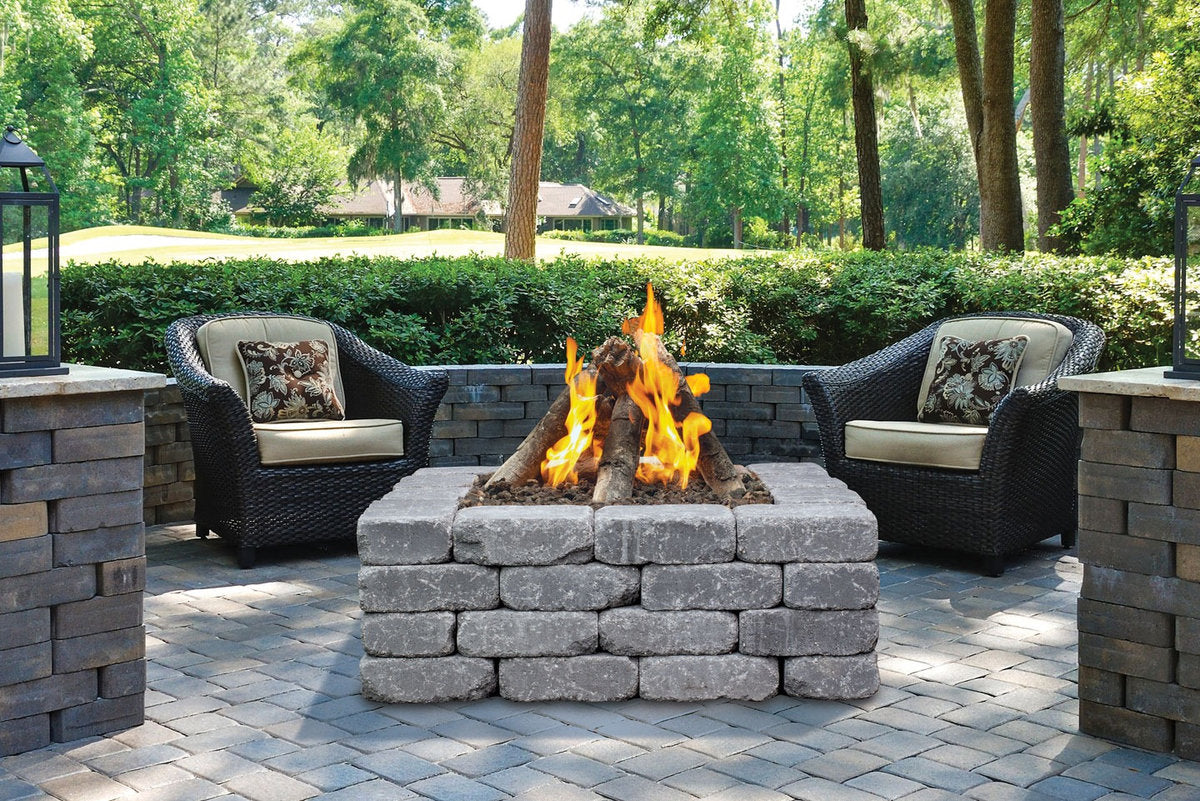 Halo 44 gas fire pit with rustic stone design and outdoor wicker seating area.