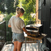 Halo Versa 16 Outdoor Pizza Oven in use on a balcony table with compact tabletop design and gas connection.