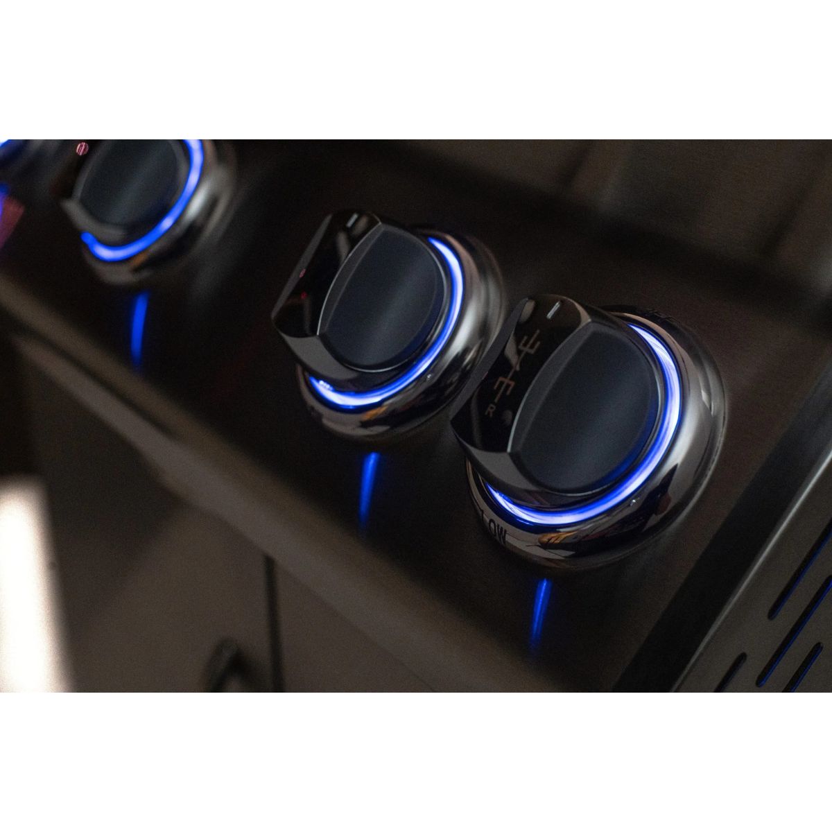 Close-up of illuminated blue LED control knobs on Jackson Grills Supreme built-in gas grill.