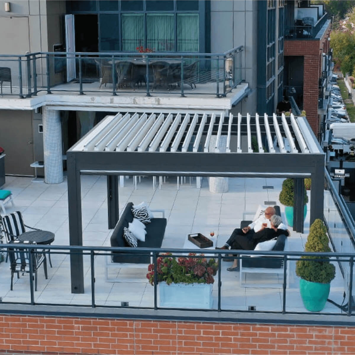 Rooftop terrace featuring a contemporary aluminum pergola with open louvered roof and lounge setup.