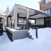 Four-season aluminum pergola installed over an elevated deck with snow-covered surroundings.