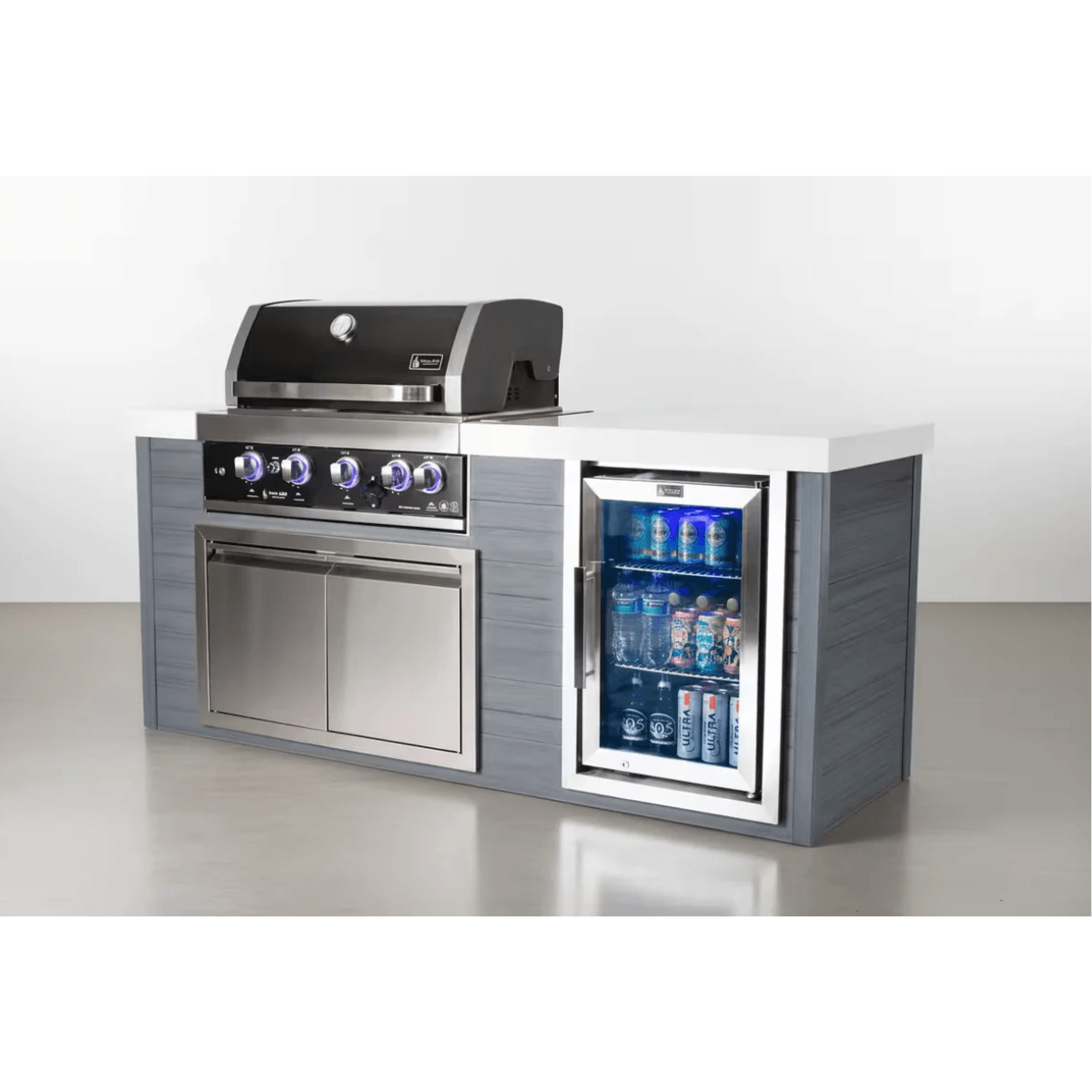 Studio display of the Mont Alpi 4-Burner Black Stainless Steel Art-wood Outdoor Island Grill featuring black stainless steel construction, storage cabinet, and built-in beverage fridge with blue interior lighting.