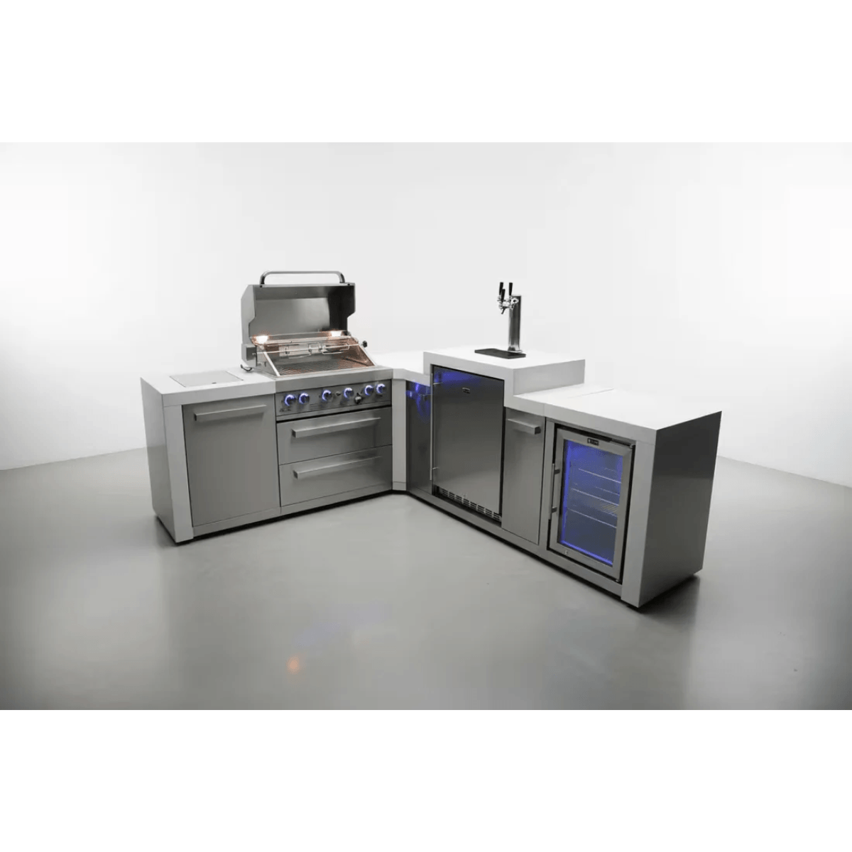 Studio view of the Mont Alpi 400 Deluxe Island with open grill hood, illuminated control knobs, integrated kegerator, fridge cabinet, and L-shaped countertop configuration.