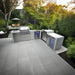 Mont Alpi 400 Deluxe outdoor kitchen installed on a patio, featuring a 90-degree corner layout, built-in grill, kegerator, beverage centre, fridge cabinet, and stainless steel storage.