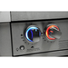 Close-up of illuminated Mont Alpi grill control knobs with blue and red LED lighting, showing the infrared side burner controls on a black stainless steel outdoor kitchen.