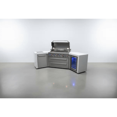 Front view of the Mont Alpi 805 Deluxe Island with 45-degree corners, featuring an open gas grill, double storage drawers, side cabinet, and integrated outdoor fridge with blue interior lighting.