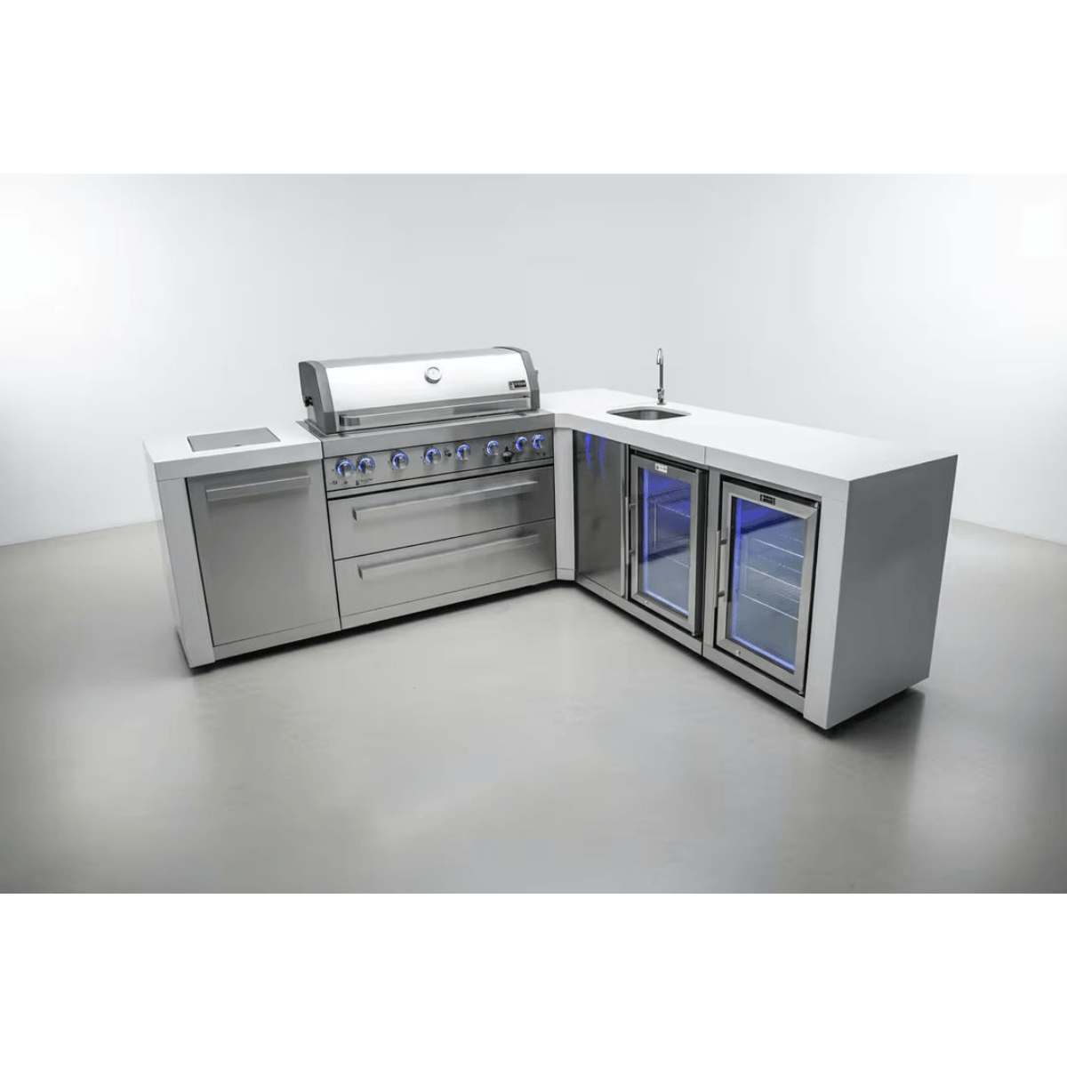 Studio view of the Mont Alpi 805 Deluxe Island featuring a gas grill, sink, beverage center, fridge cabinet, and stainless steel storage in an L-shaped configuration.