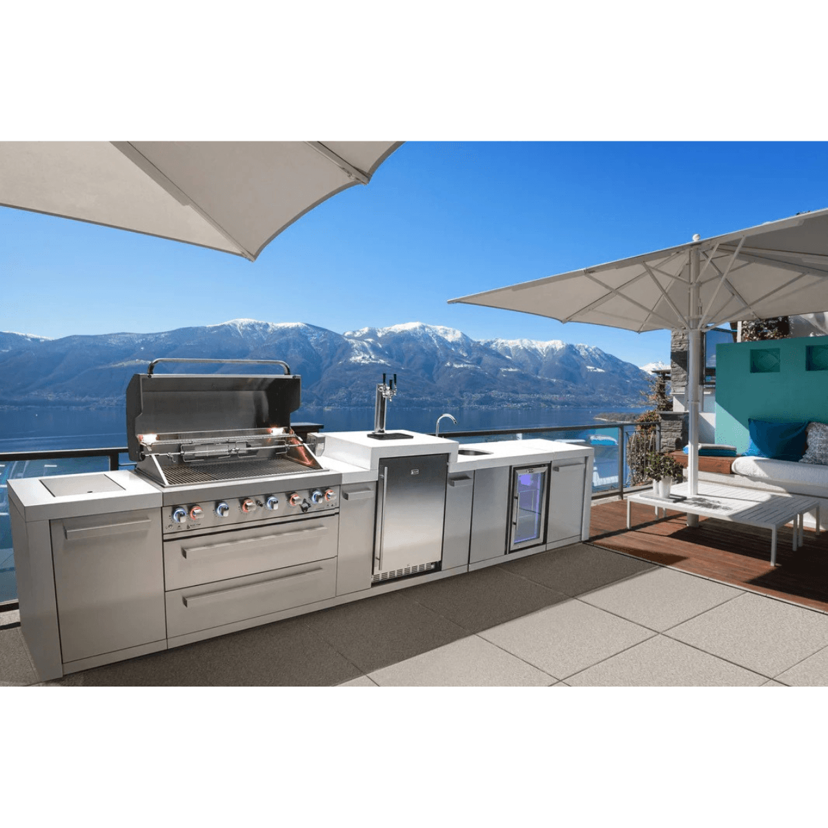 Mont Alpi 805 Deluxe Island with kegerator and beverage center installed on a luxury outdoor terrace overlooking a lake and mountain landscape.