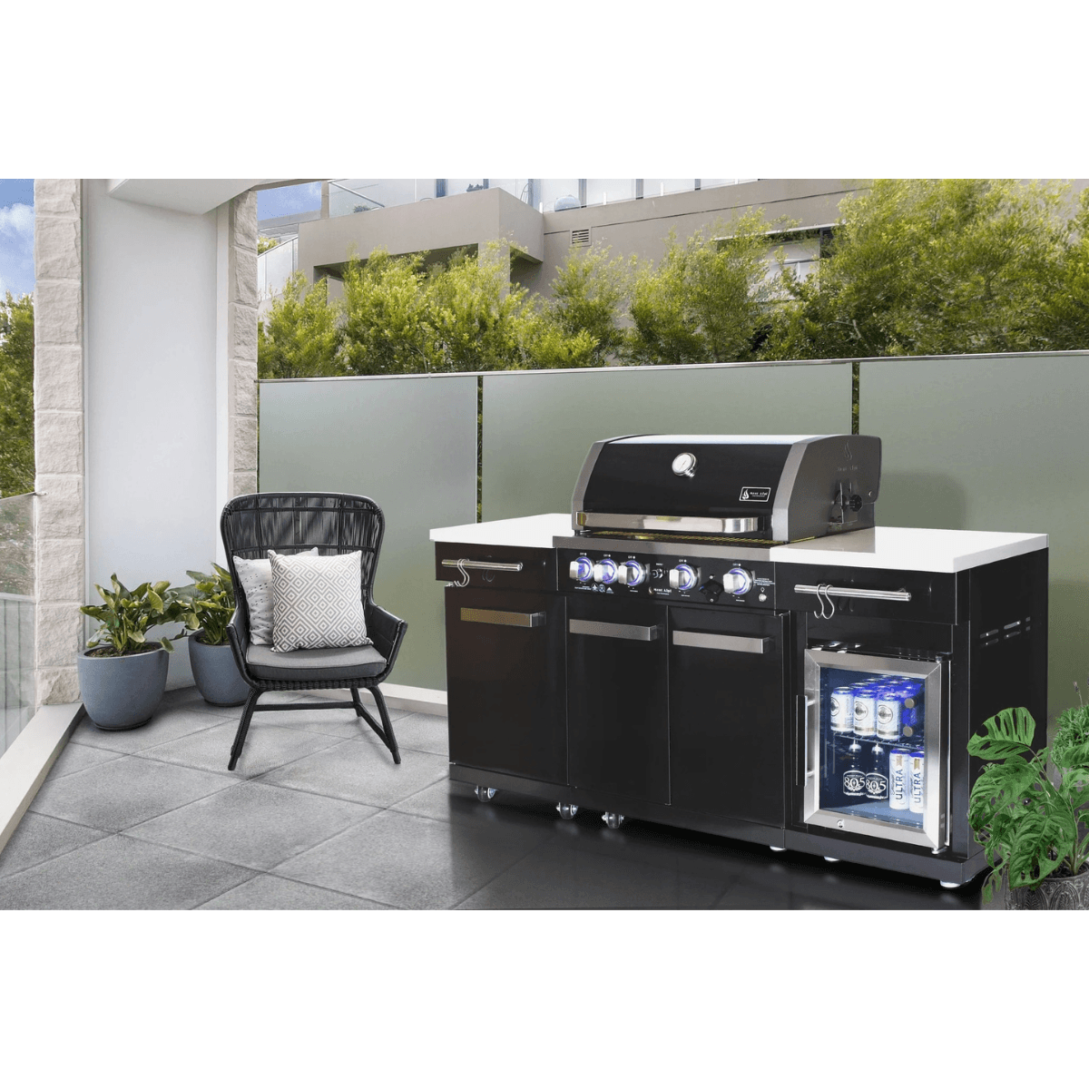 Mont Alpi 957 Black Stainless Steel Island installed on a modern outdoor patio with built-in compact refrigerator and storage cabinets.