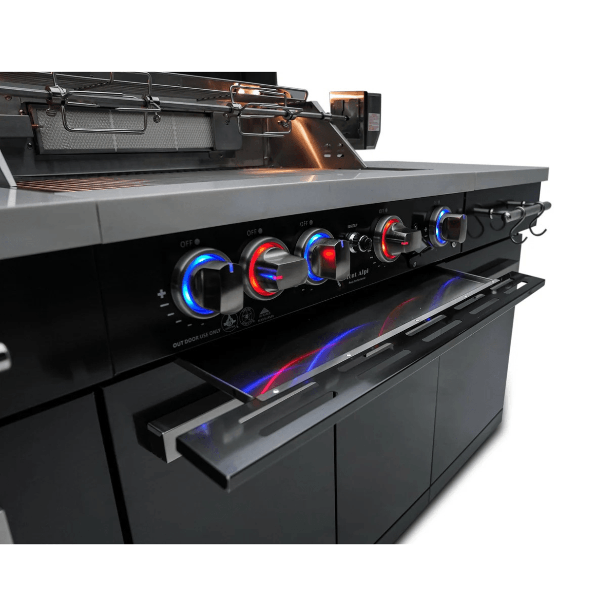 Angled close-up of the Mont Alpi 957 Island control panel featuring LED-lit burner knobs and stainless steel warming shelf.