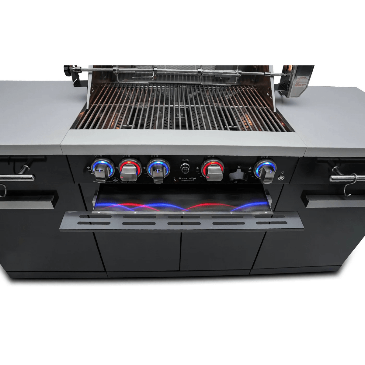 Front view of the Mont Alpi 957 Island with open grill hood, cooking grates, rotisserie system, and illuminated control knobs.