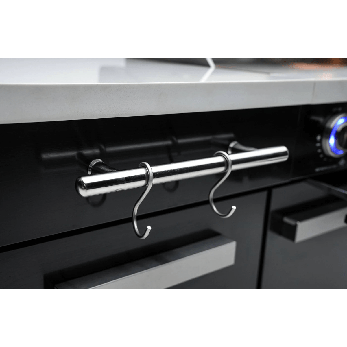 Close-up of the Mont Alpi 957 Island stainless steel utensil rail with hanging hooks mounted on the black cabinet front.