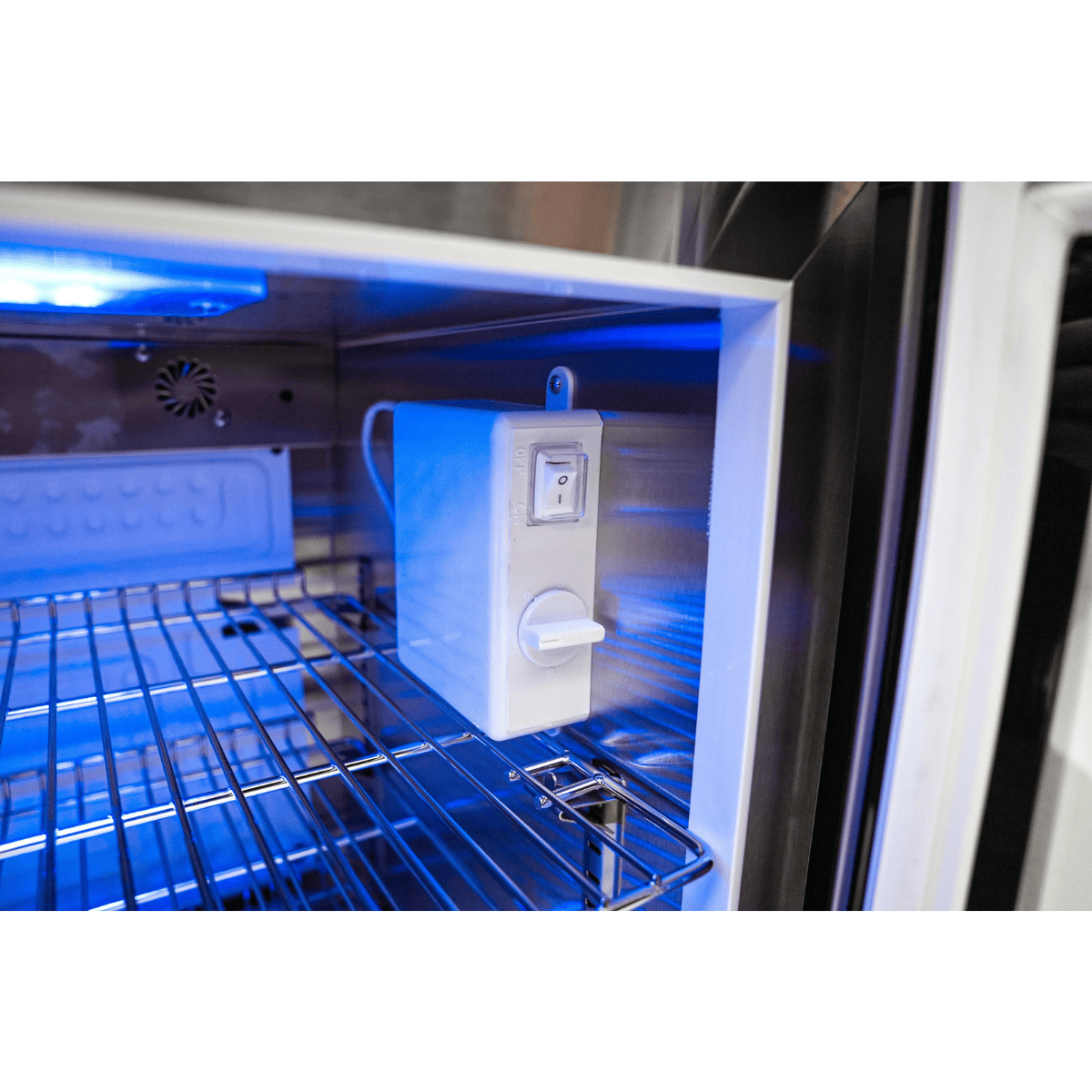 Interior view of the Mont Alpi fridge cabinet showing the temperature control unit and illuminated storage compartment.