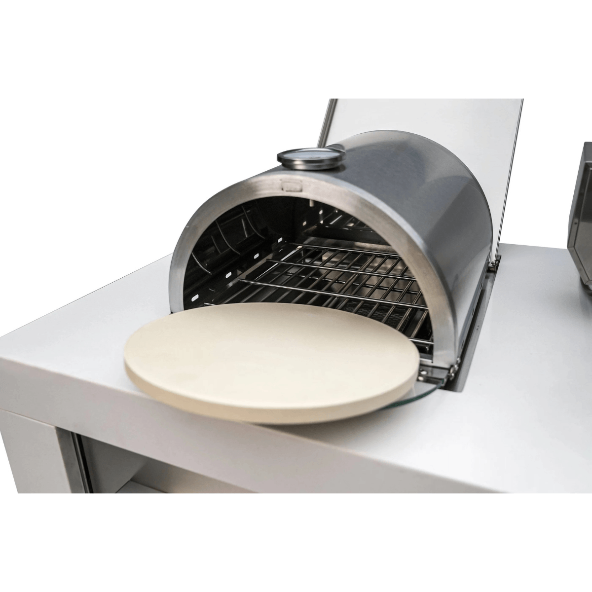 Mont Alpi universal side burner pizza oven with removable ceramic pizza stone positioned outside the cooking chamber for easy cleaning.