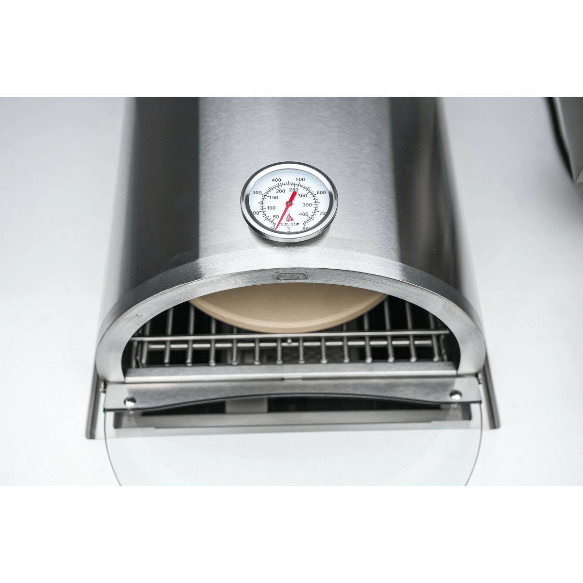 Front view of the Mont Alpi universal side burner pizza oven highlighting the ceramic pizza stone, cooking grate, and integrated thermometer.