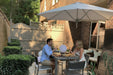 Outdoor patio setup with high chairs, table, and umbrella on a patio.
