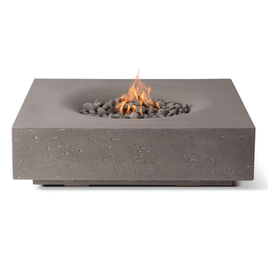 Pyromania Infinity Fire Table in grey concrete finish with lava rocks and glowing fire flame.