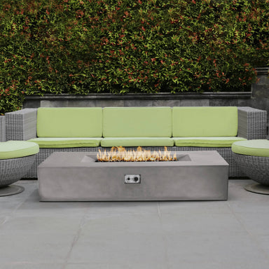 Front view of the Pyromania Laguna concrete fire table with active flame and control panel.
