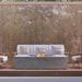 Pyromania Moderne fire table with outdoor lounge seating and wood privacy screen backdrop.