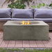 Pyromania Tao concrete fire table with wicker sofa seating and active gas flames.
